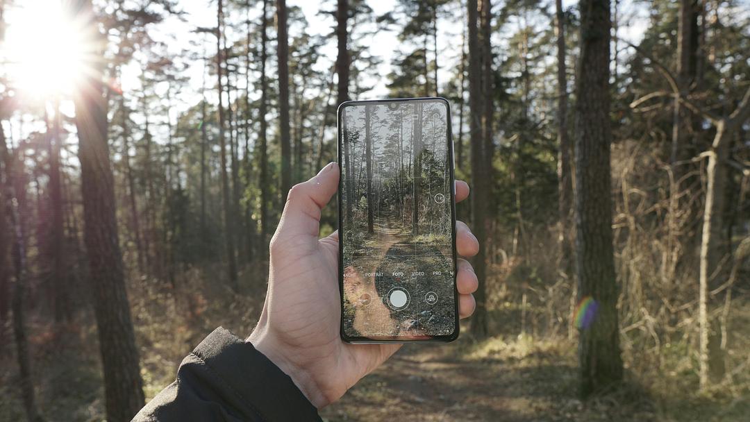 Person holding a smartphone up to view their surroundings through the device's camera and screen