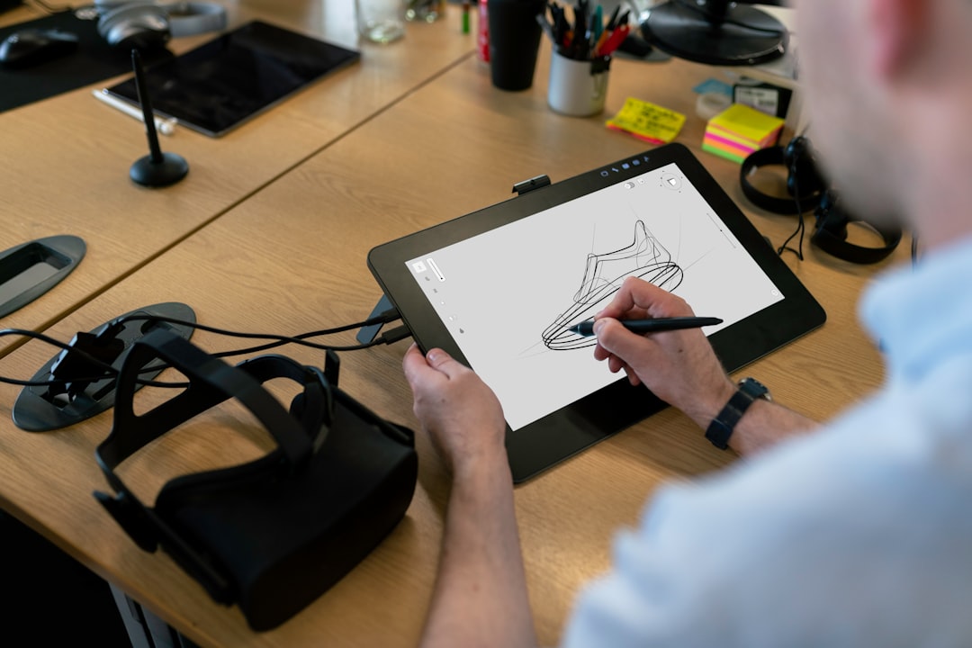 Design engineer sketching on a tablet while testing a virtual reality software model