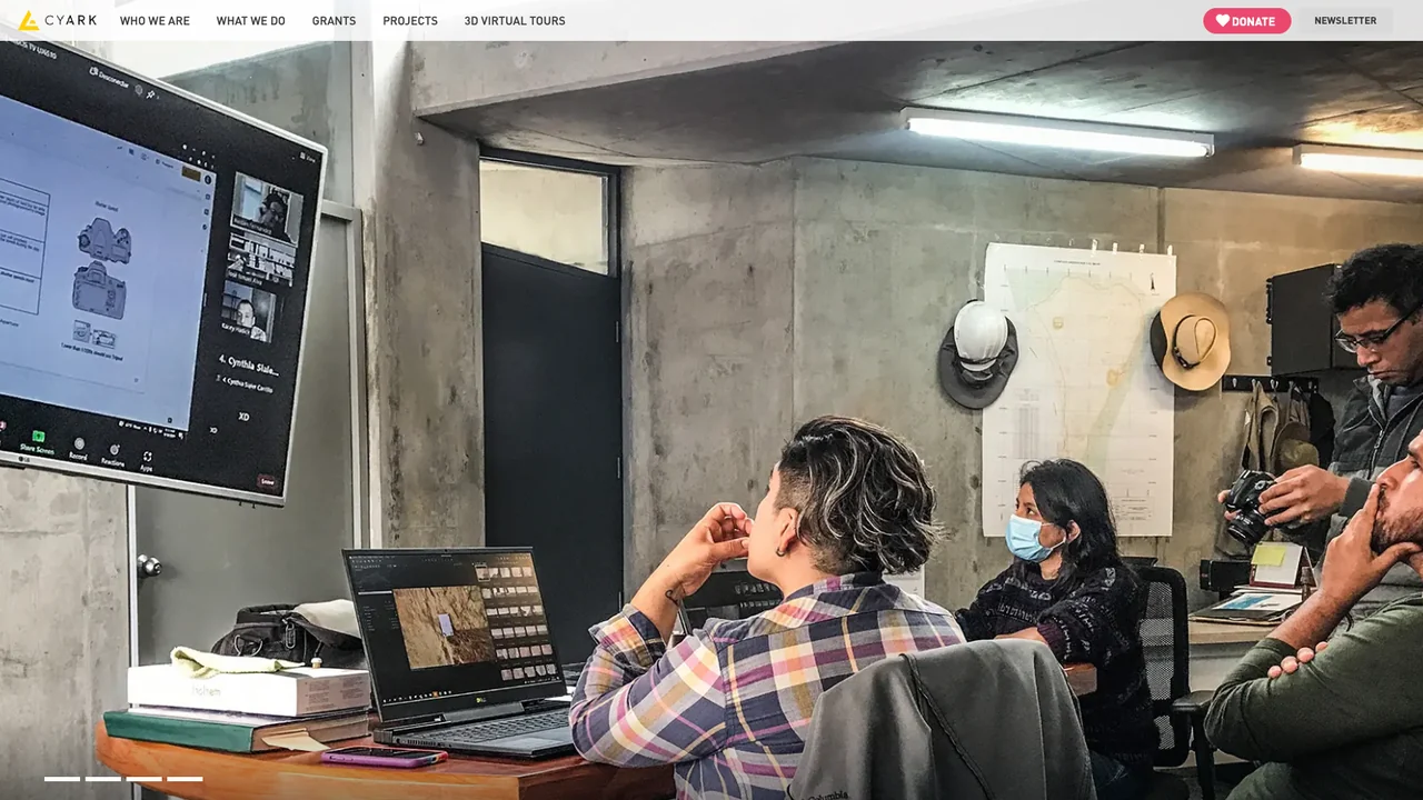 CyArk website homepage, showing heritage professionals in a training session reviewing 3D documentation on screen.