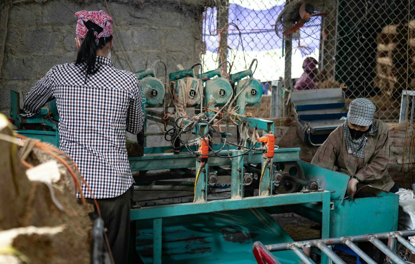Assembly line workers operating machinery on a manufacturing floor