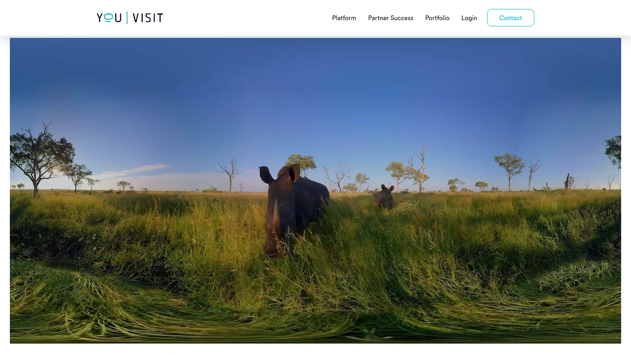 YouVisit homepage showing a 360 degree panorama of rhinos standing in tall grassland at dusk