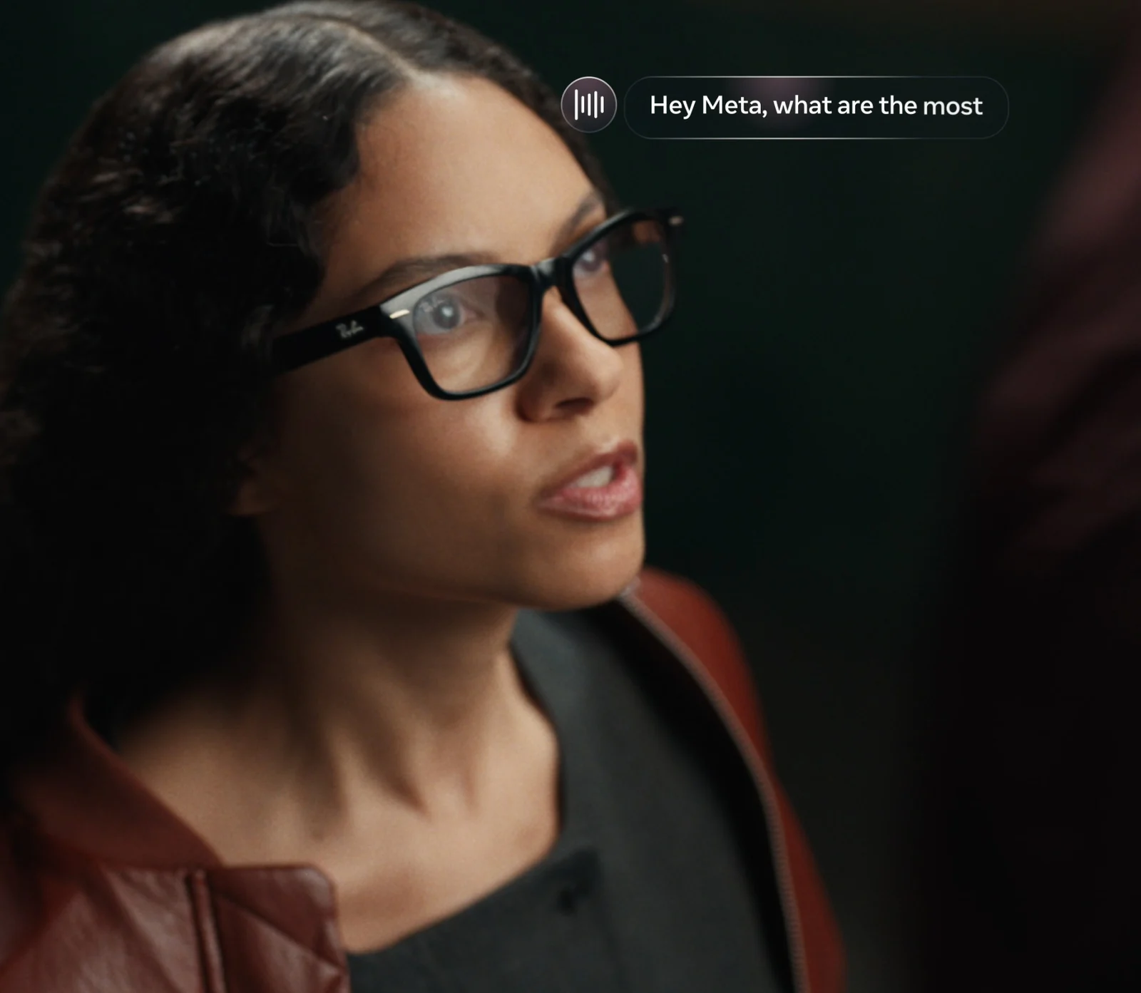 Person wearing black rectangular Ray-Ban Meta Audio glasses with clear lenses and no camera in the frame corner, with an overlaid voice prompt reading Hey Meta, what are the most
