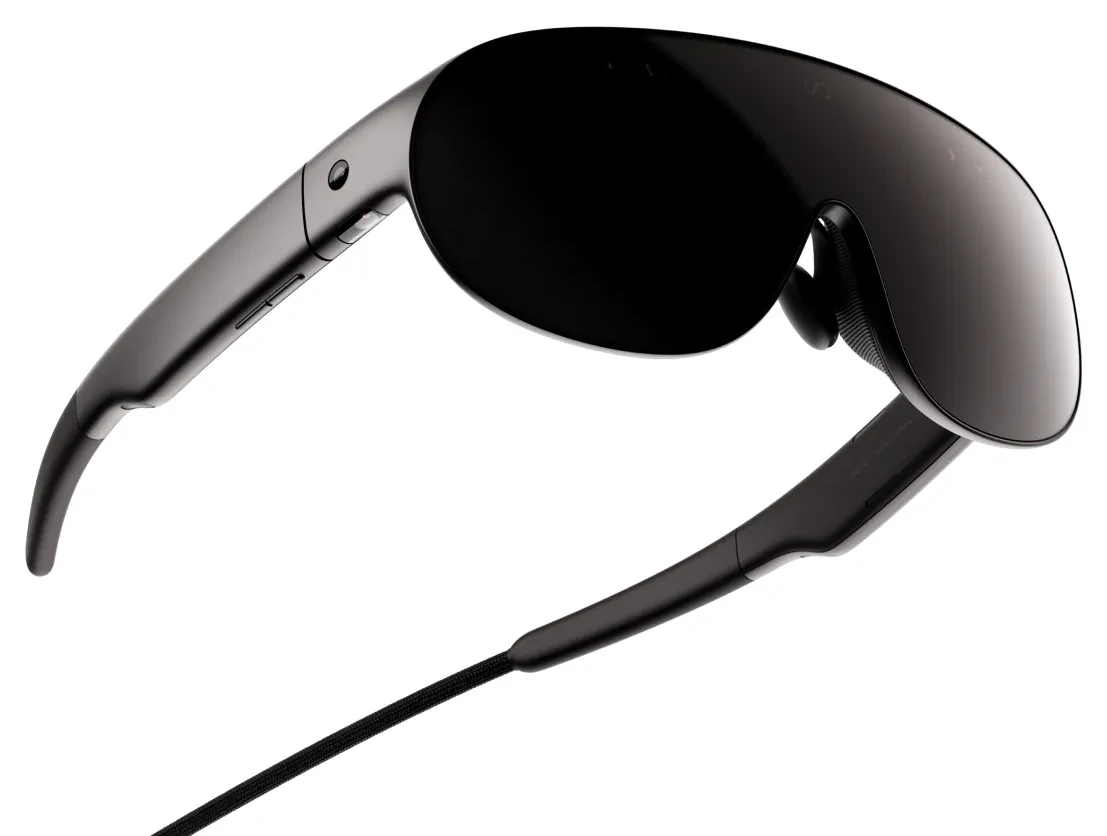 Meta VR Glasses seen from the right at three quarters on a white background, showing the dark visor, the thin temple arm and the braided tether running out of it