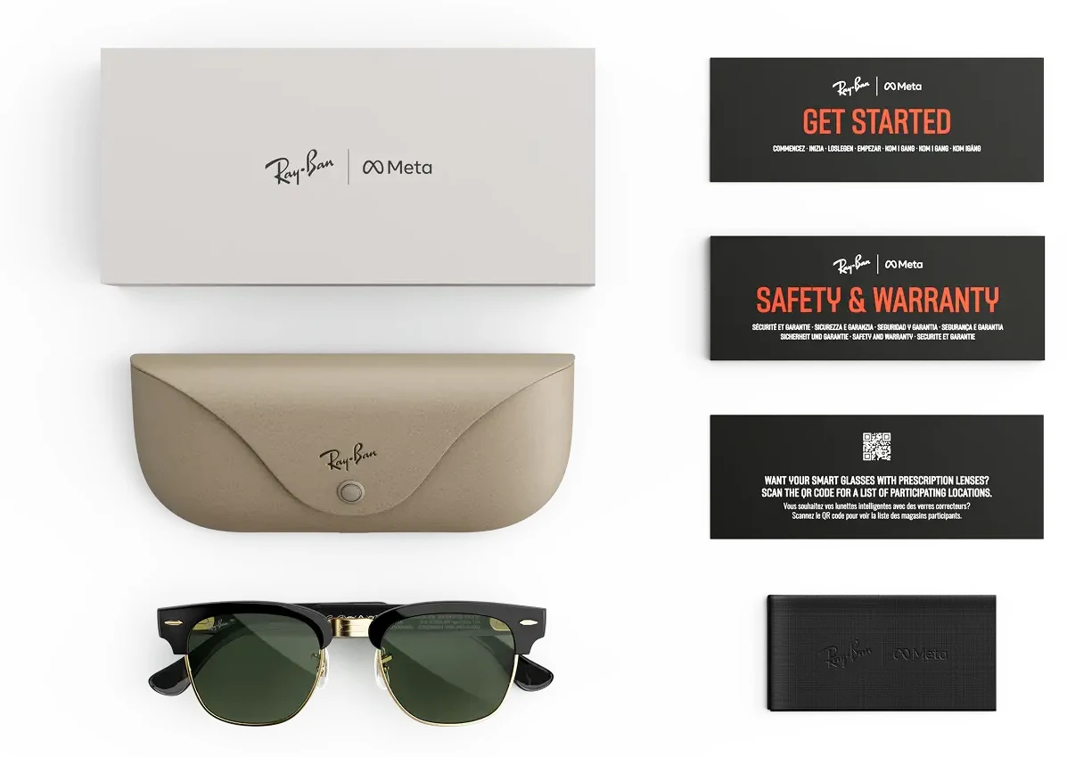 Flat lay of the Ray-Ban Meta Audio Clubmaster box contents on white: an outer sleeve, a taupe fold-over case, the black and gold Clubmaster glasses, a Get Started card, a Safety and Warranty card, a prescription card with a QR code and a cleaning cloth