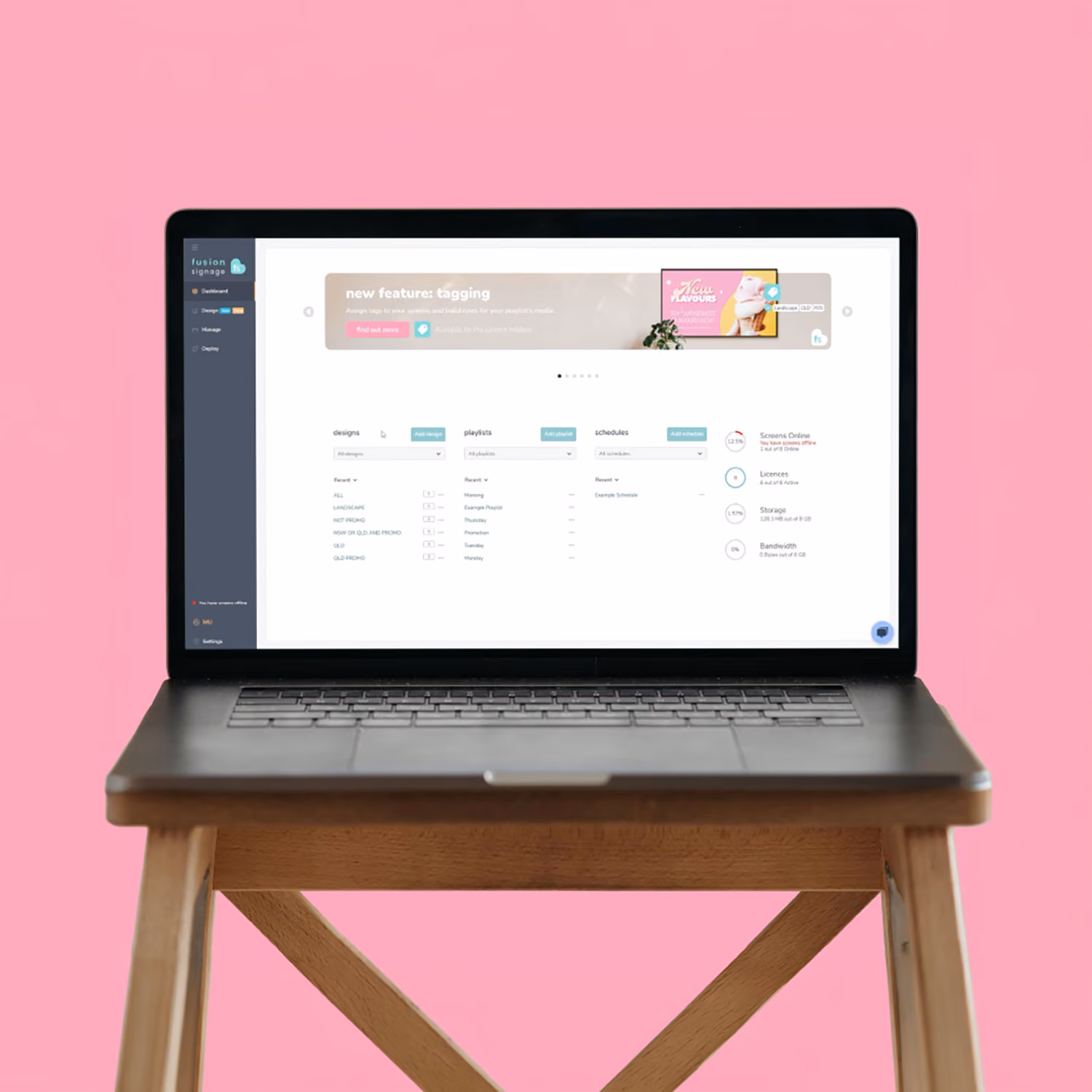 Open laptop on wooden stand displays software dashboard with tagging feature and media management.