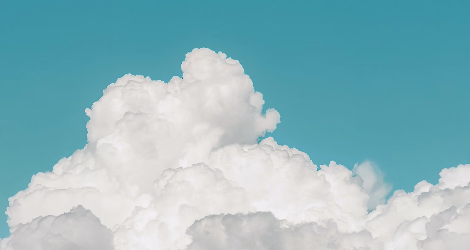 Large fluffy white clouds against a clear blue sky.