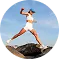 Woman stretching leg forward on a sandy beach during sunset with blue sky and clouds.