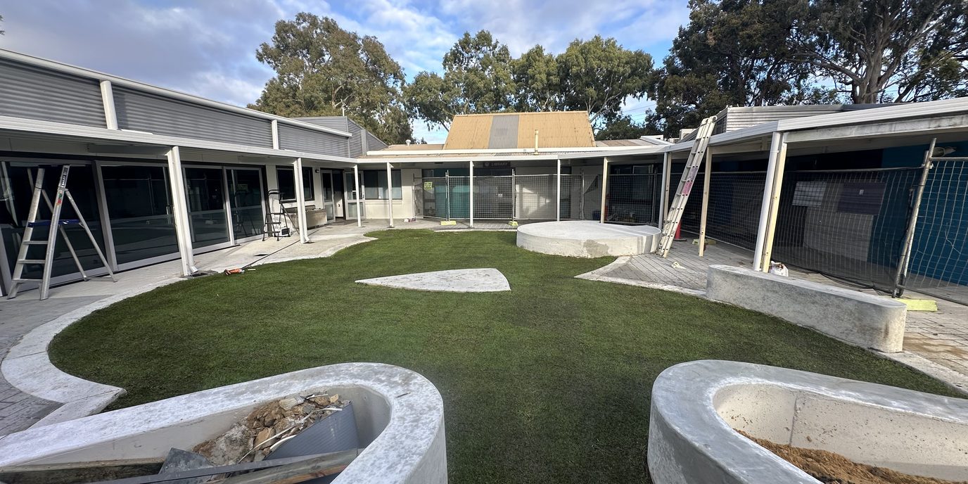 New turf in an open courtyard between buildings