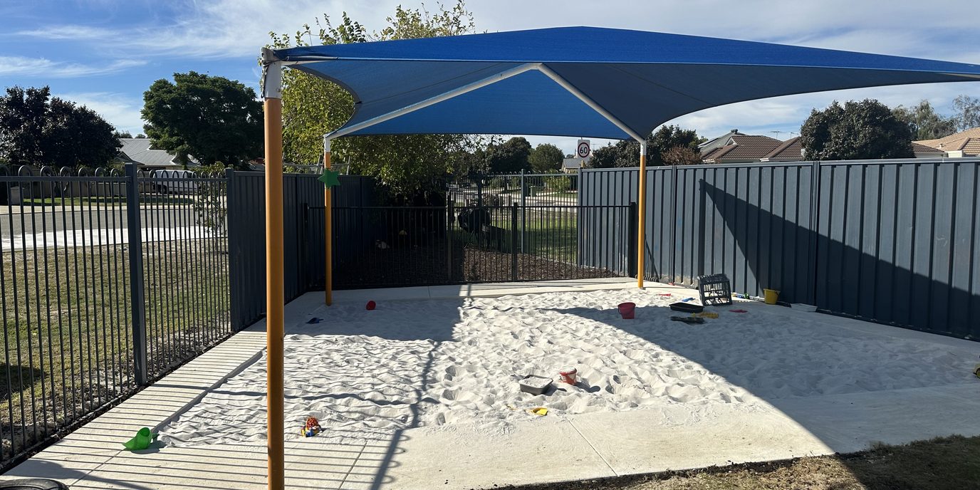 Playground sandpit install with shade sail and play items