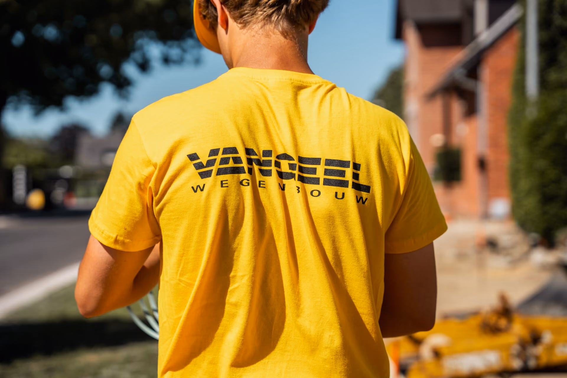 Vangeel Wegenbouw arbeider in geel T-shirt op de werf
