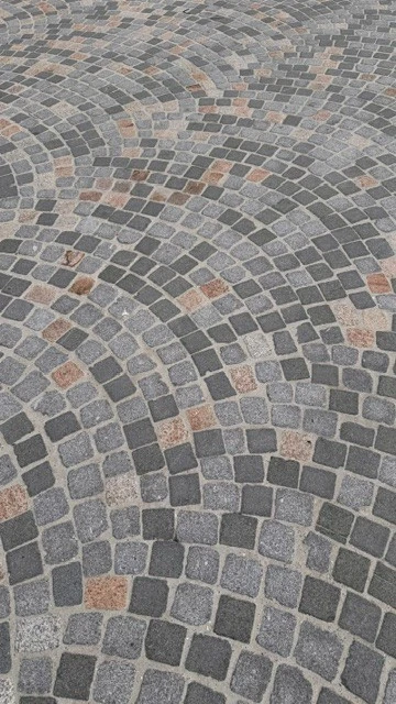 Detail van de gebogen kasseiverharding op het kerkplein