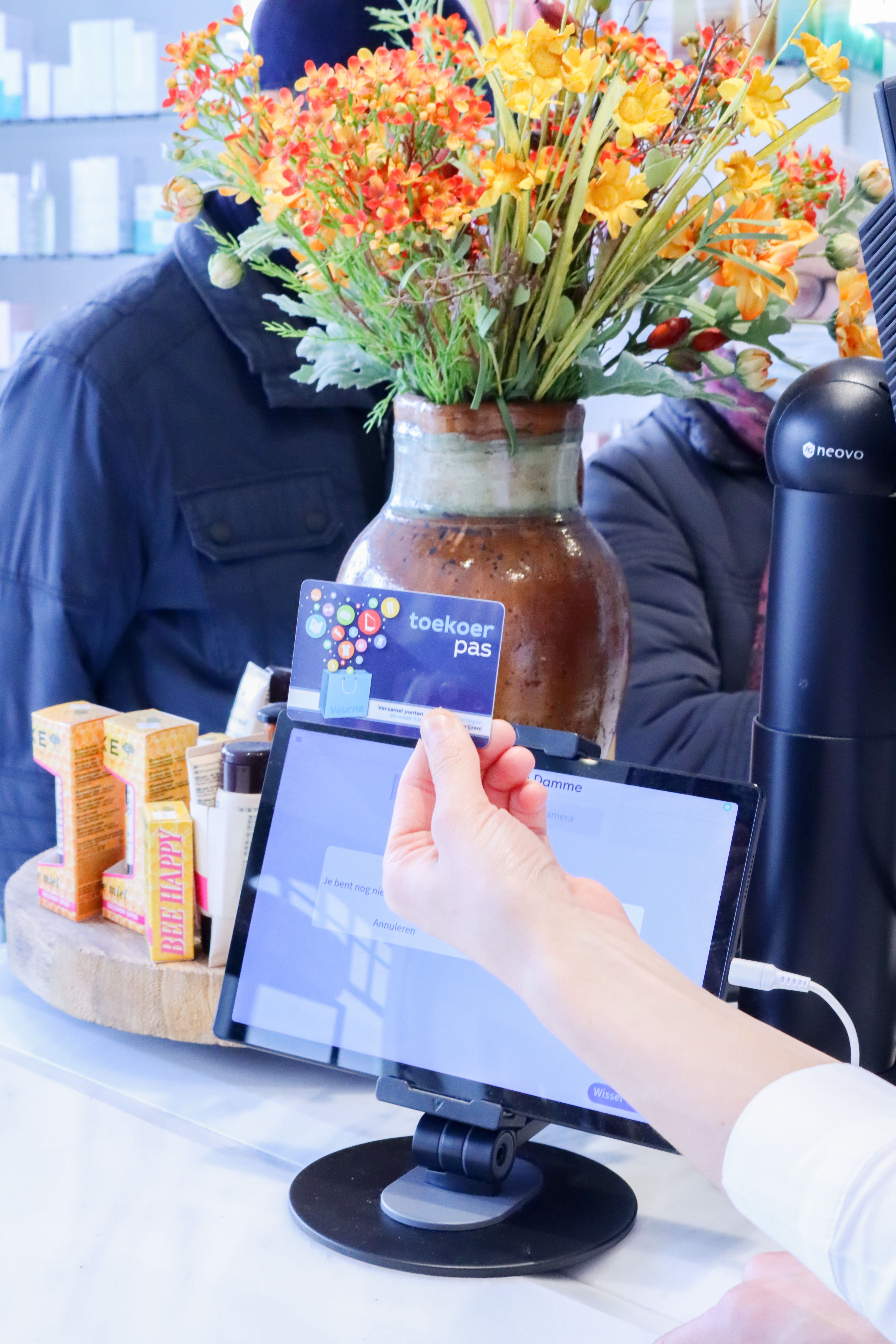 Klant betaalt met de Toekoerpas aan de balie van Apotheek Van Damme