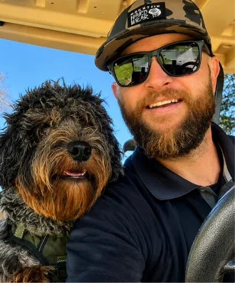 A happy customer taking a selfie with his mountain doodle dog on a boat.