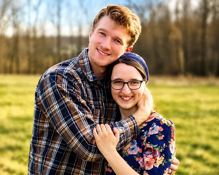 Bekah and her husband hugging and smiling at the camera.