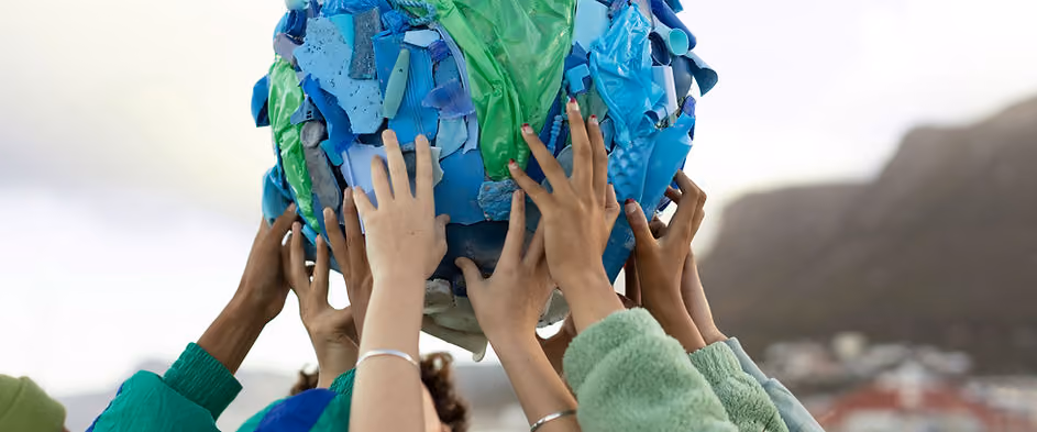 Many hands holding up discarded materials forming a globe