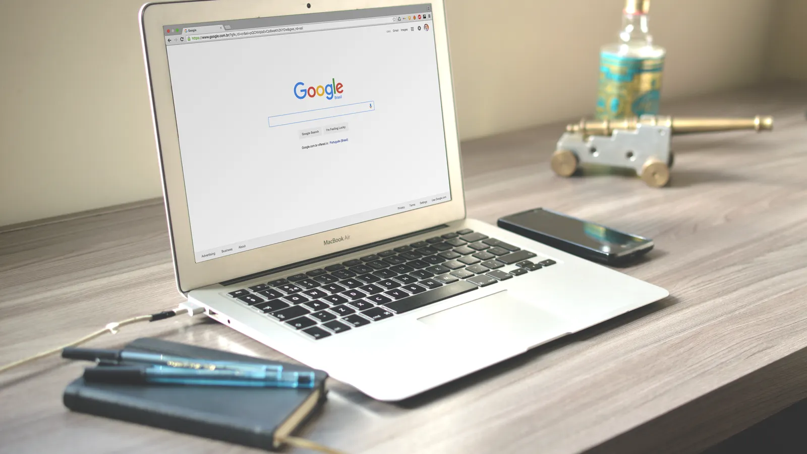 Laptop and smartphone in a search workspace, representing SEO, AEO and GEO across traditional and AI-assisted discovery