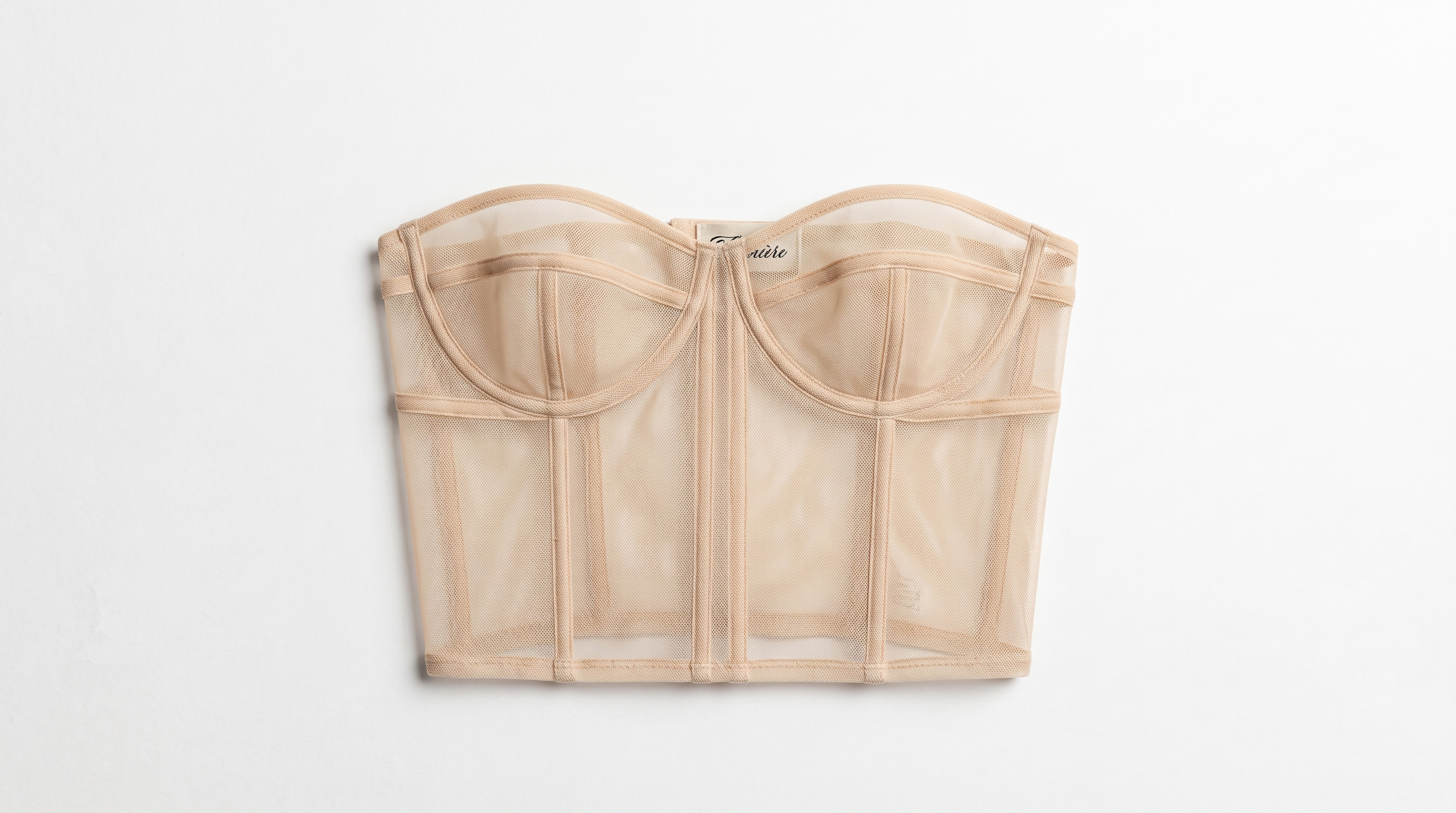 Nude mesh corset with panel seams and structured cups, laid flat