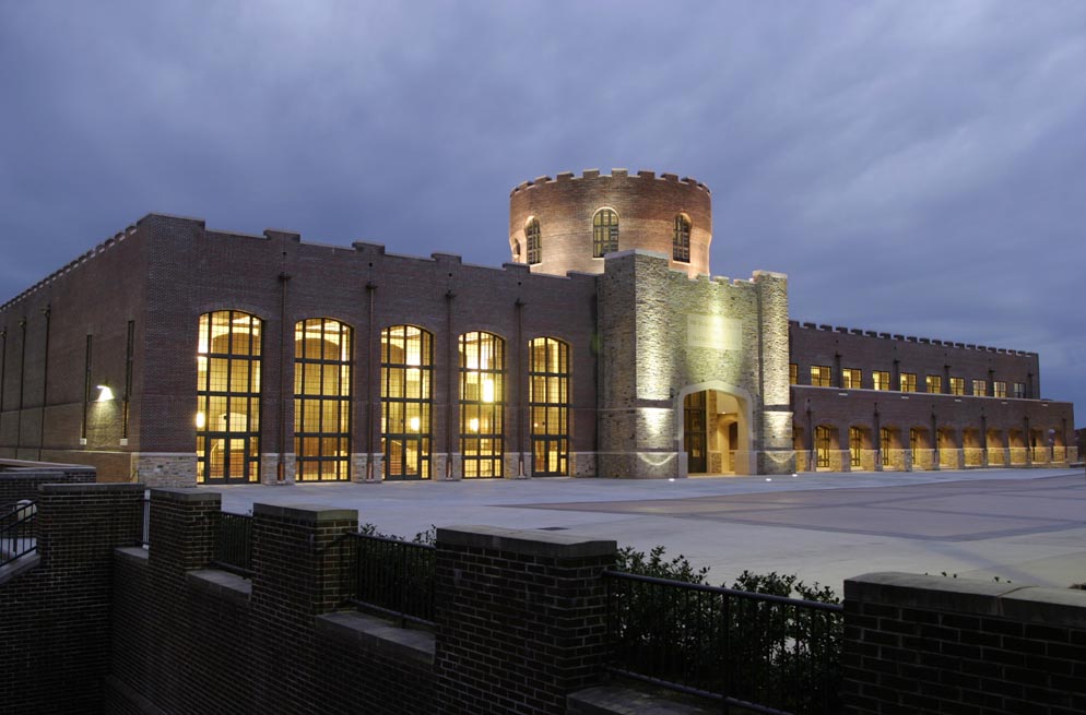 Riverside Military Academy Sandy Beaver Performing Arts Center at dusk, a brick castle-style building with lit arched windows and turret