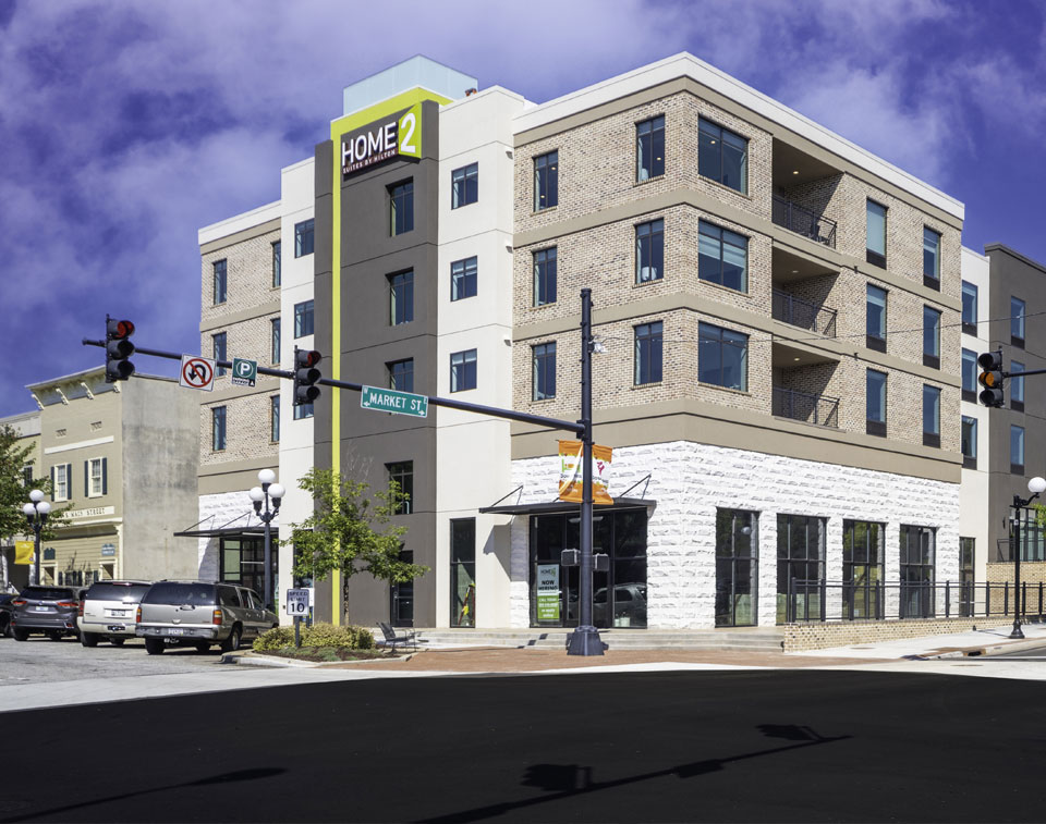 Home2 Suites by Hilton on Market Street, a four-story brick and stucco hotel at a downtown corner