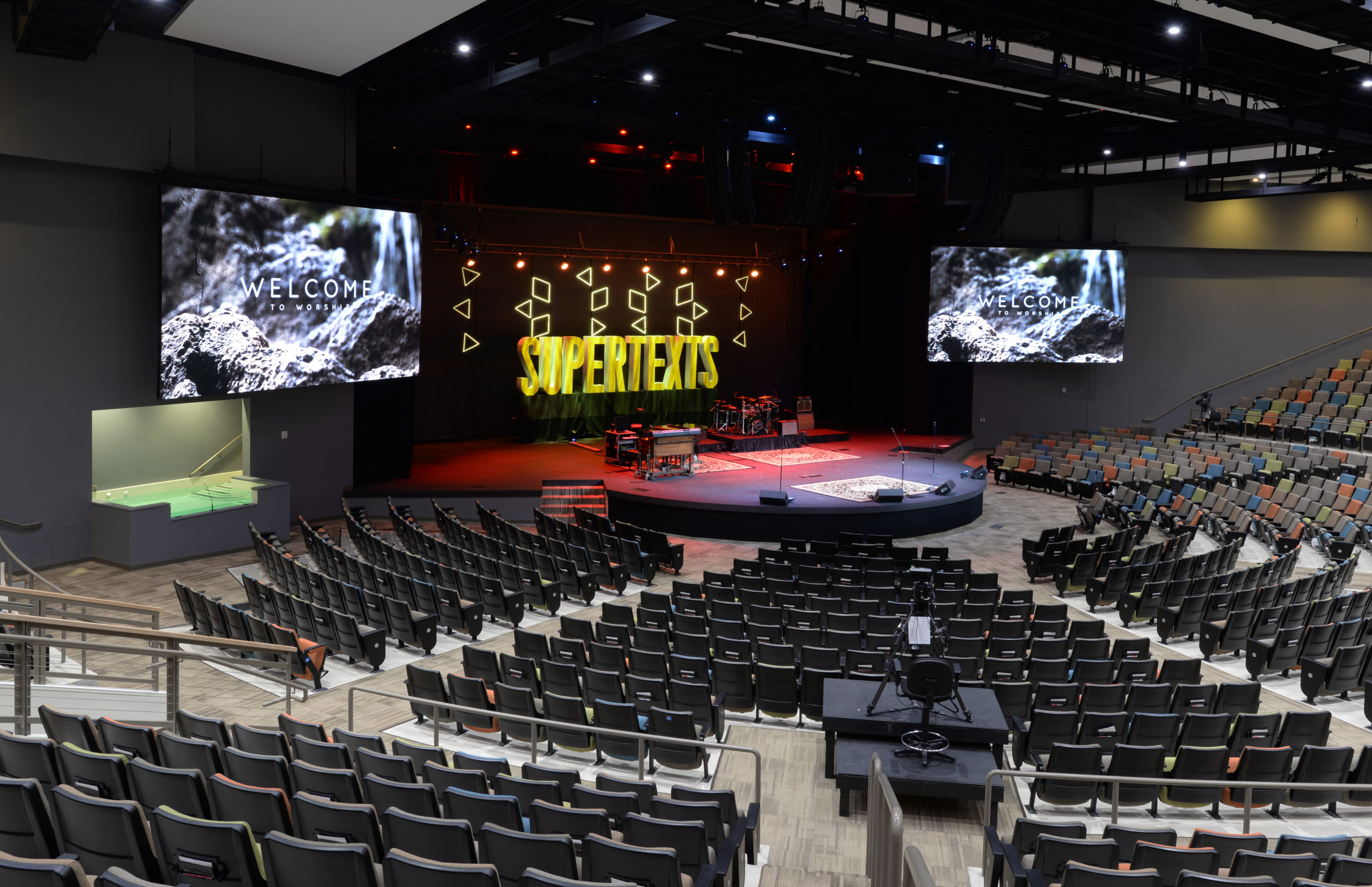 Compassion Church sanctuary interior with stage, large welcome screens and tiered seating