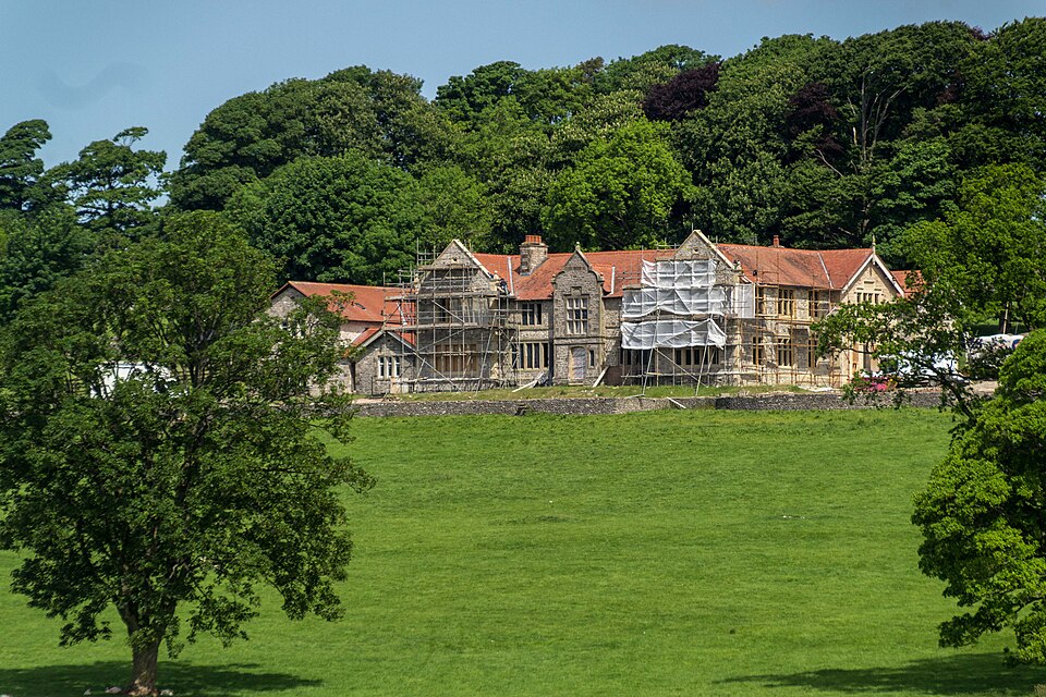 Large stone country house undergoing renovation, with scaffolding around the façade.