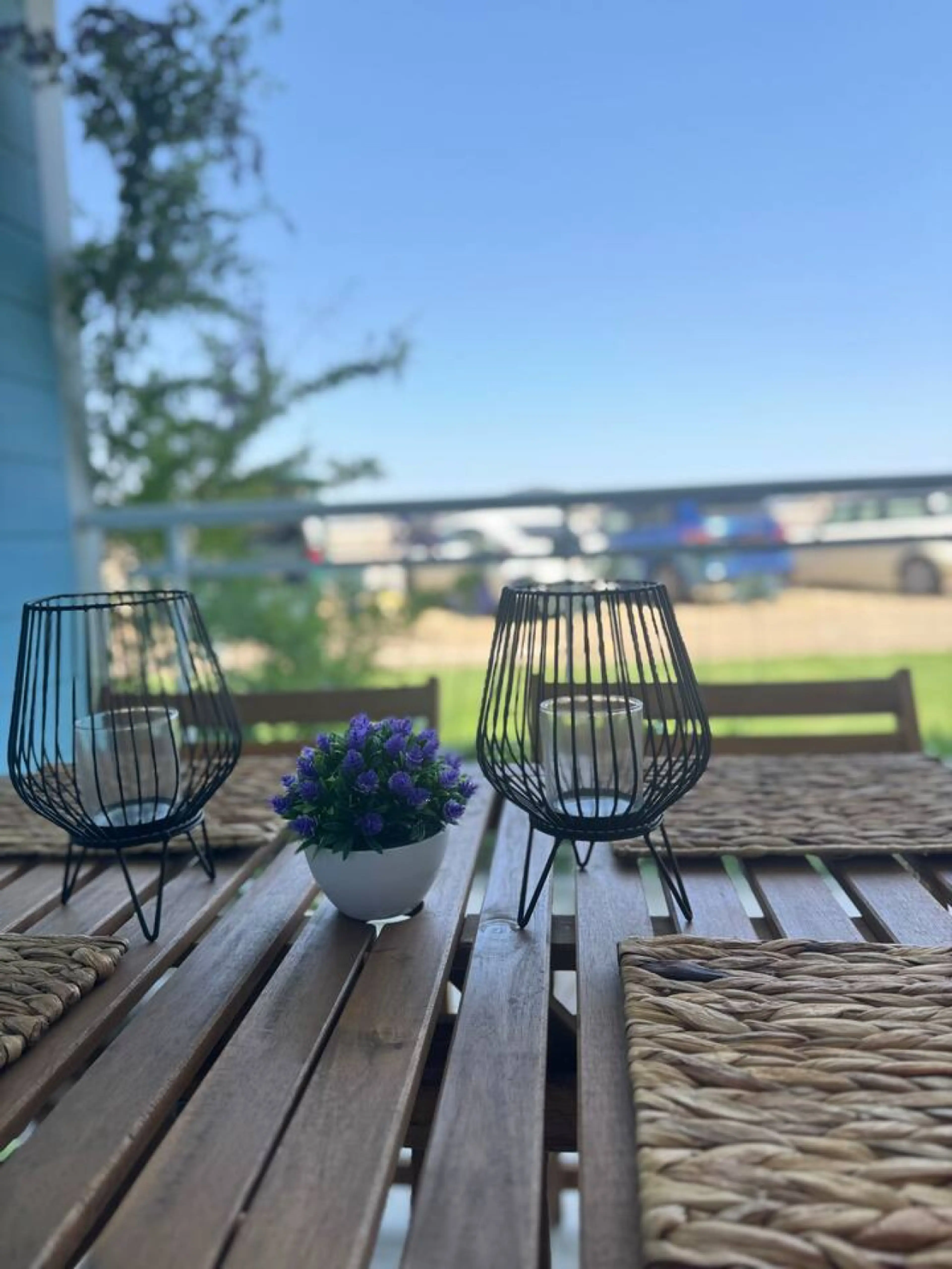Balcony table with lanterns and flowers at a Marina Club apartment on a clear day