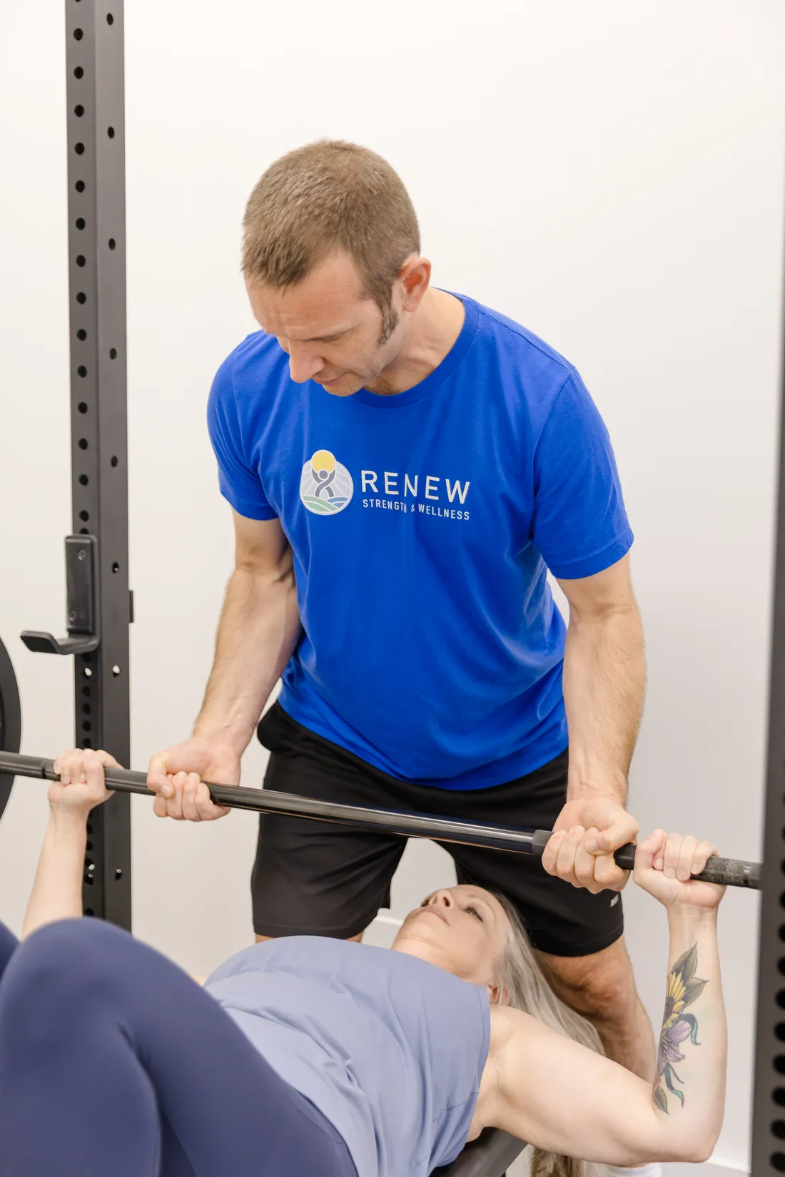 Matt Rieder, DPT, spotting a patient on the bench press at Renew Strength & Wellness in St. Augustine, FL