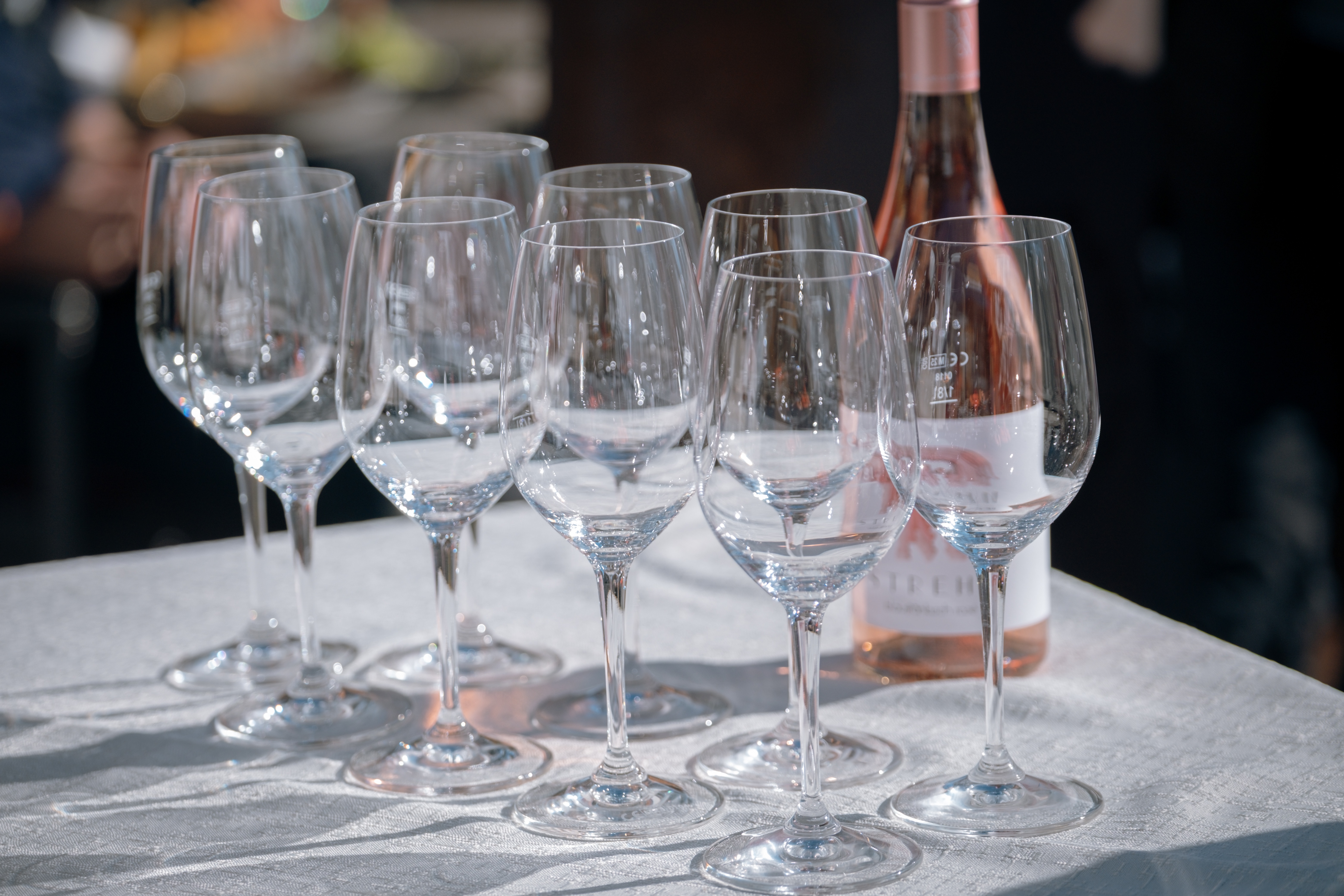 Wijnglazen en een fles rosé klaar op een tafel in de zon