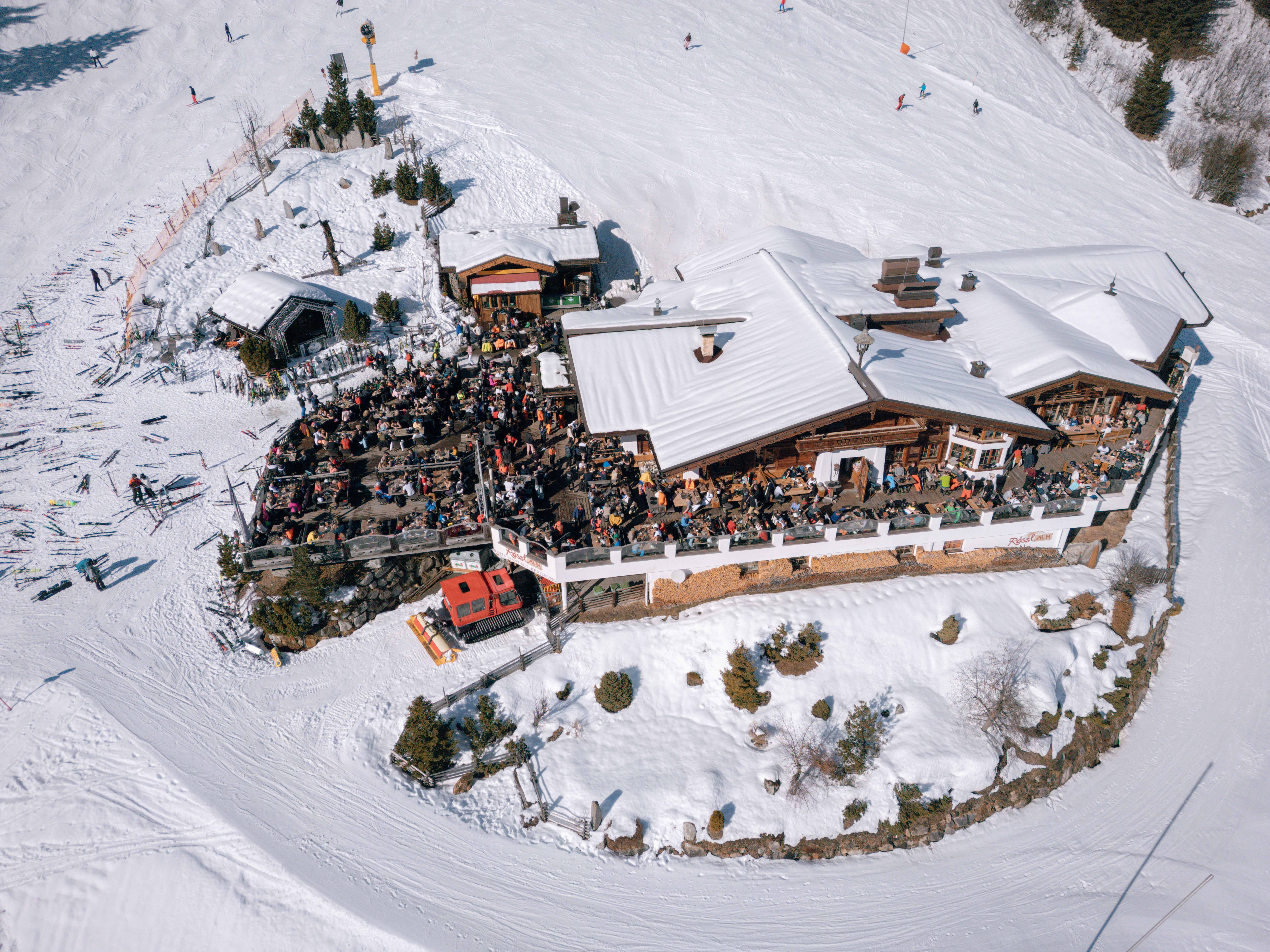 Luchtfoto van de Rössl Alm met het volle terras aan de piste
