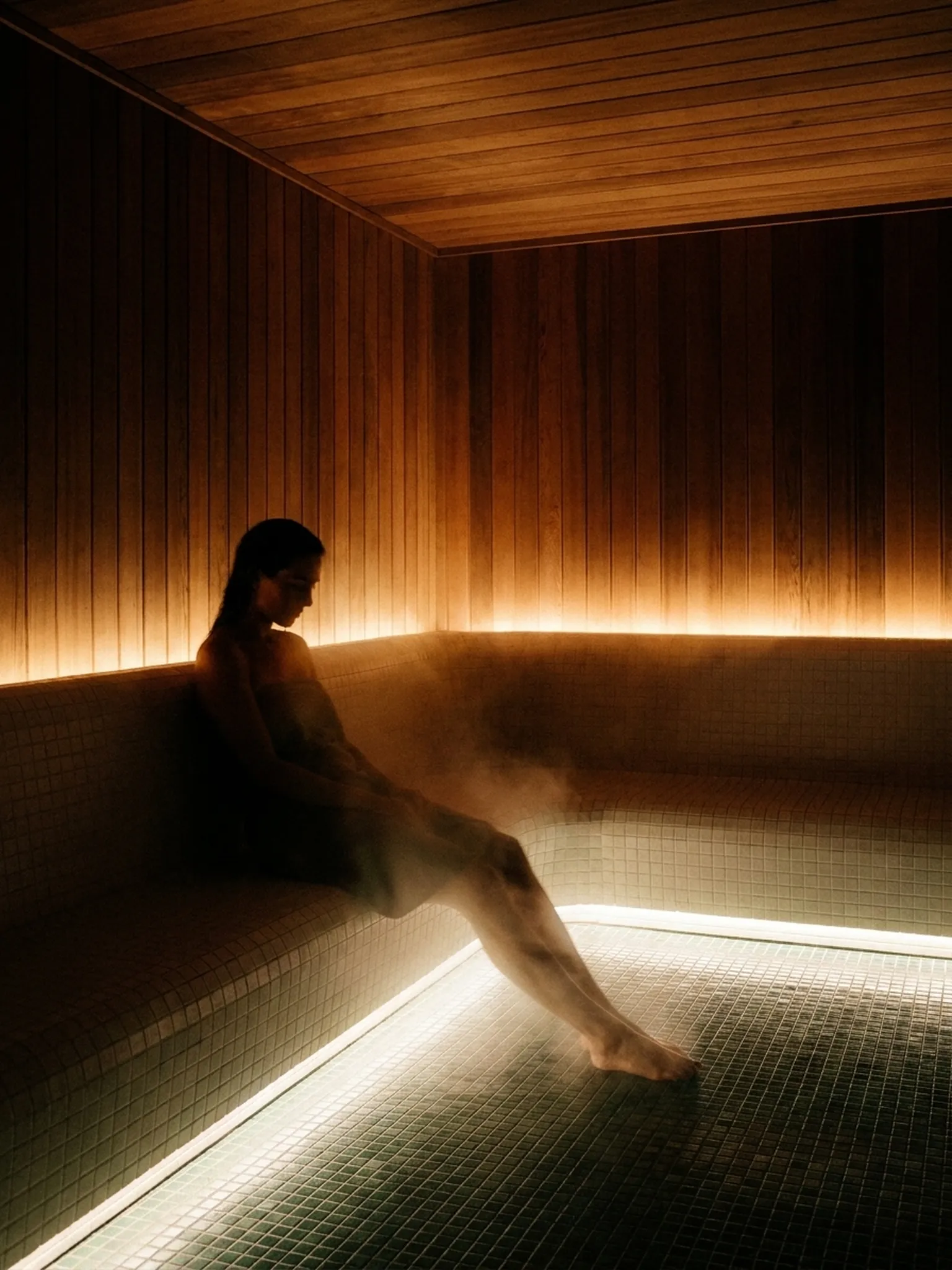 A guest seated in VELA's cedar sauna