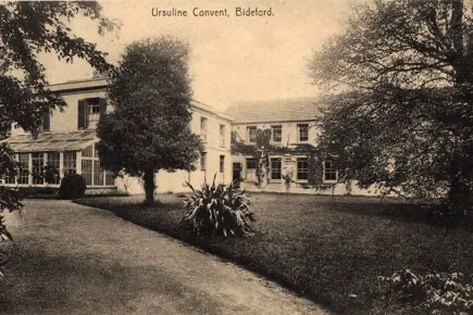 Sepia-toned photograph of Ursuline Convent in Bideford, showing a large two-story building with a conservatory on the left, surrounded by trees and a lawn with a pathway leading towards the entrance.