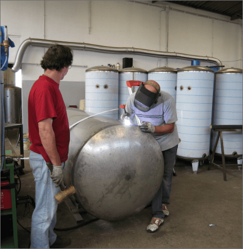 Técnico da Ferreinox a soldar um termoacumulador em aço inox na oficina localizada em Aveiro, Portugal.