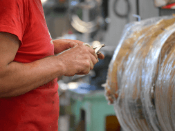 Pormenor das mãos de um técnico da Ferreinox a utilizar uma ferramenta no fabrico de um termoacumulador em aço inox.