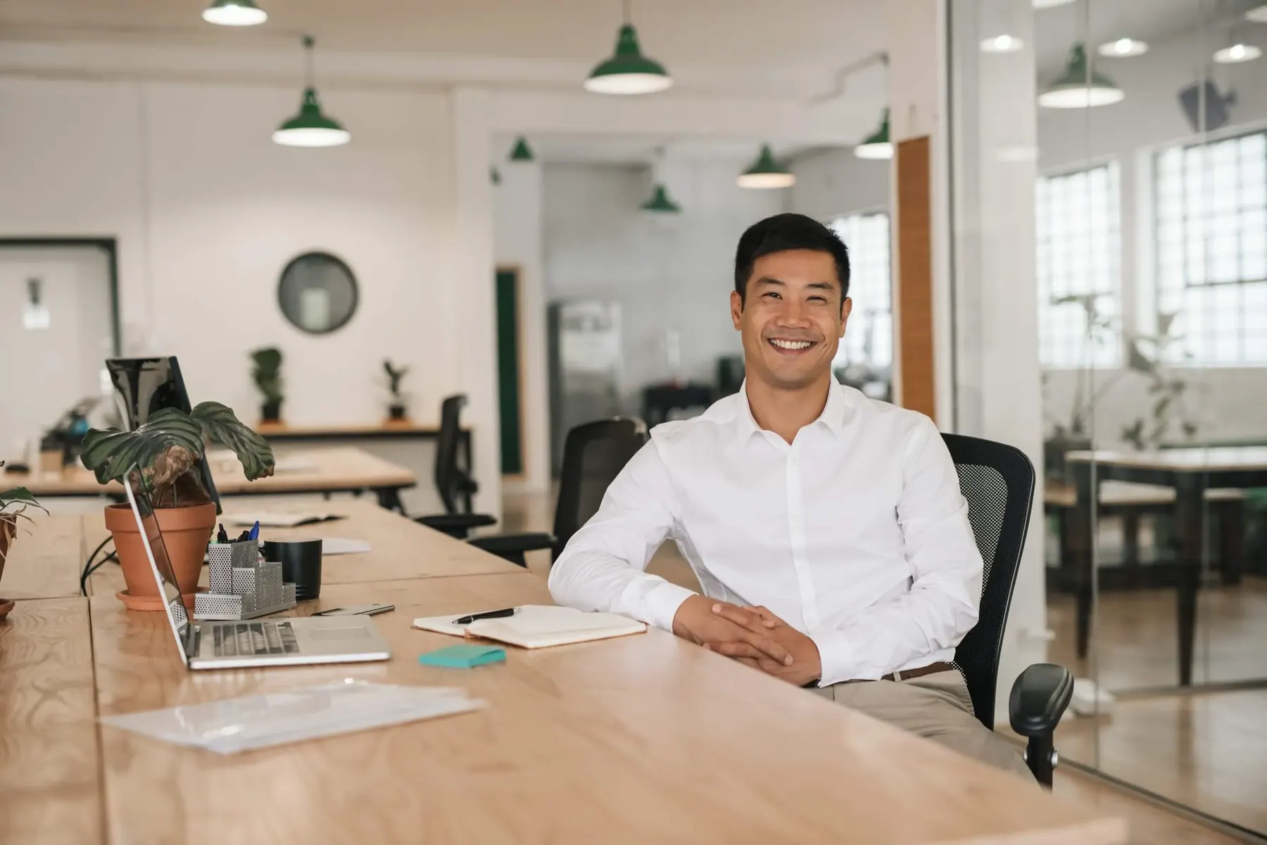 Client Success Manager smiling at a desk in an open-plan office