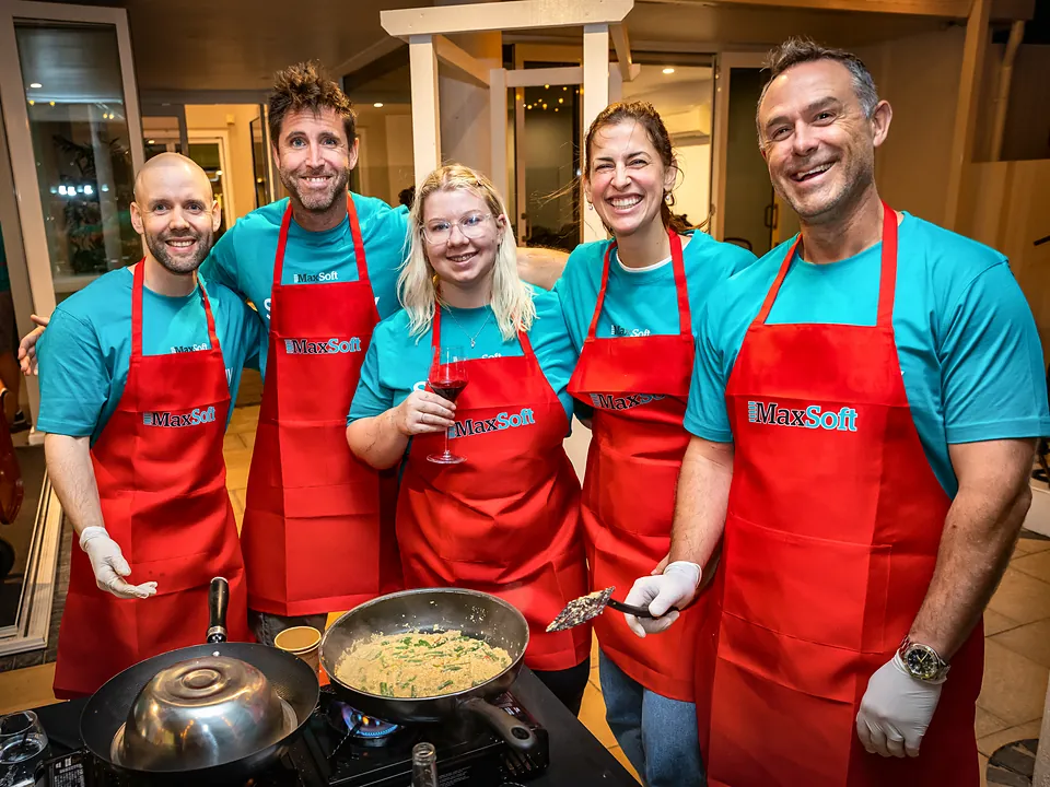 StrataMax team members in aprons at a team cooking challenge