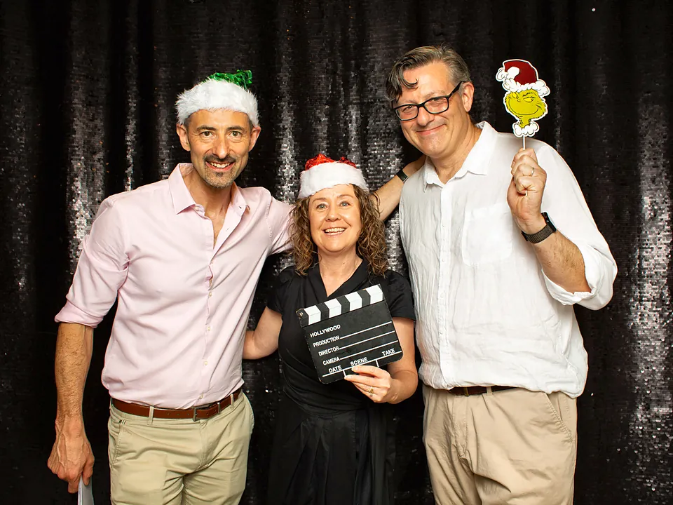 Three StrataMax team members with props at a Christmas photo booth