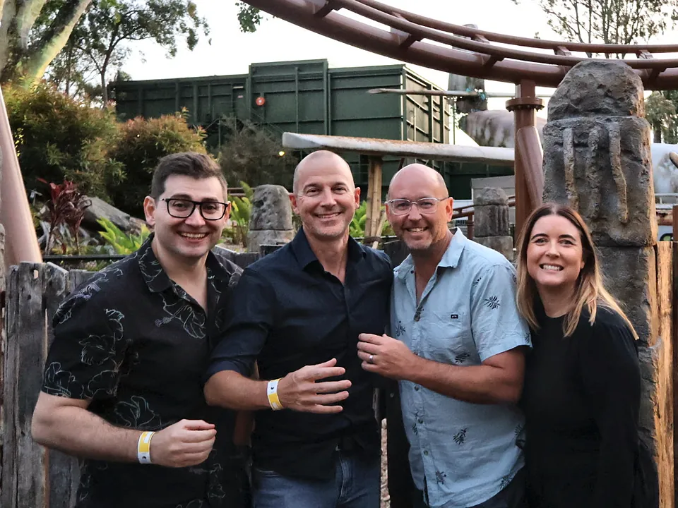 Four StrataMax team members at a theme park in the evening
