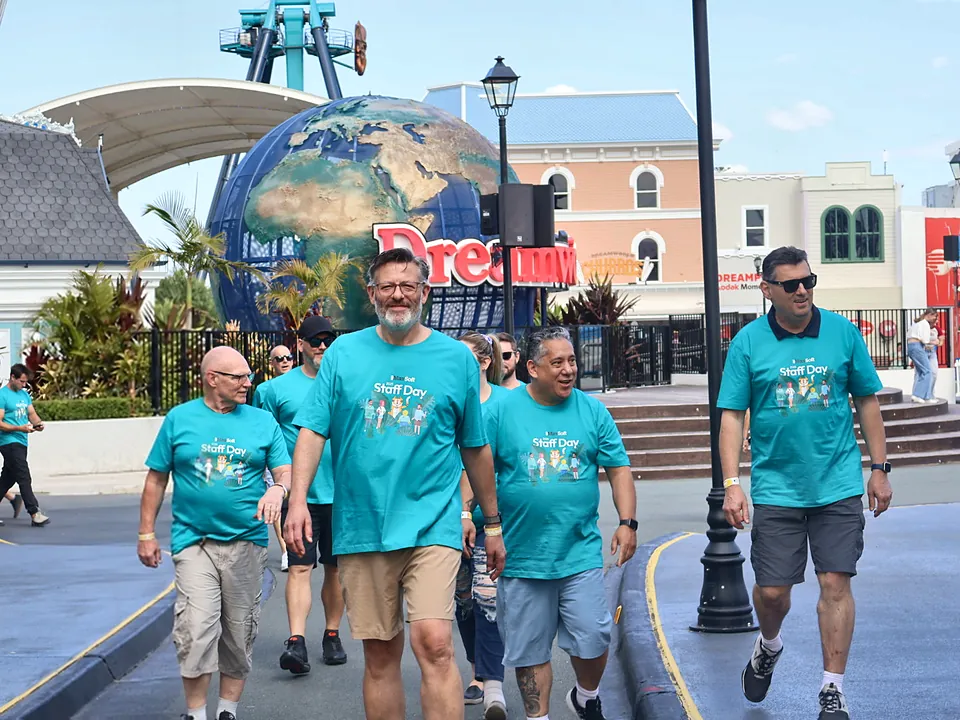 StrataMax team in Staff Day shirts walking through a theme park