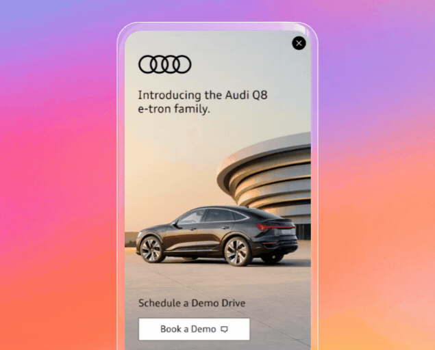 Advertisement showing a black Audi Q8 e-tron parked in front of a modern curved building at sunset, with text introducing the Audi Q8 e-tron family and a button labeled 'Book a Demo' to schedule a test drive.