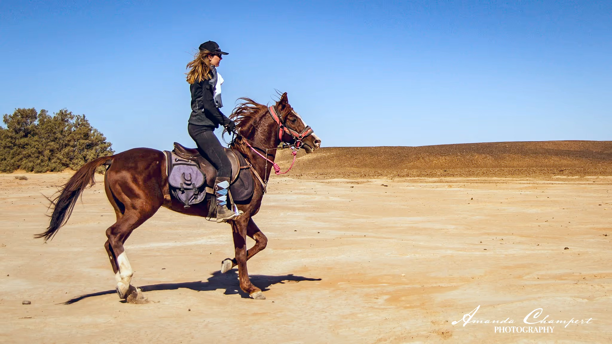 Une cavalière équipée pour une randonnée guidée de plusieurs jours dans le désert d’Agafay au Maroc.