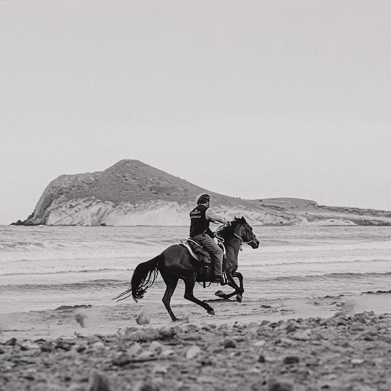 Un cavalier galope sur une plage de sable lors d’une randonnée équestre en Andalousie.