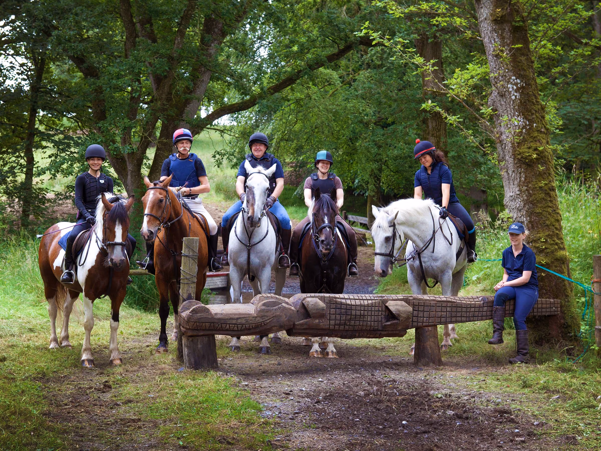 Un groupe de cavaliers posant pour une photo dans les bois lors d’un séjour équestre à Castle Leslie en Irlande.