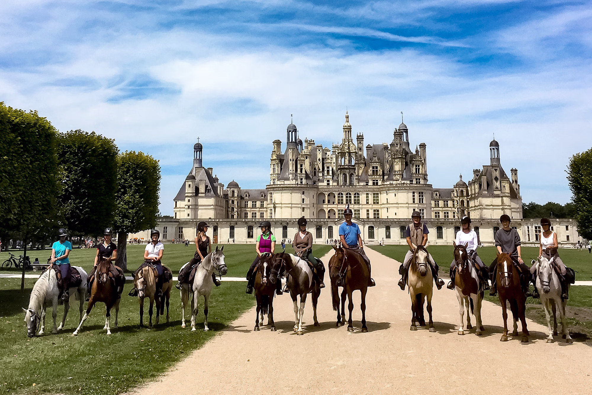 Groupe de cavaliers et leurs chevaux posant devant un Chateau de la Loire lors d'un voyage organisé a cheval en France