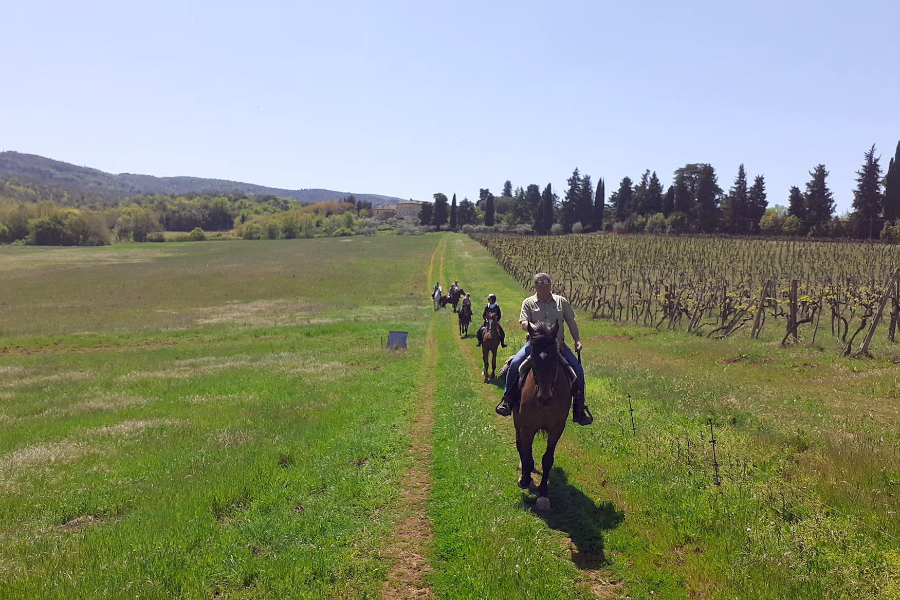 Des cavaliers au galop près des vignobles de Toscane.