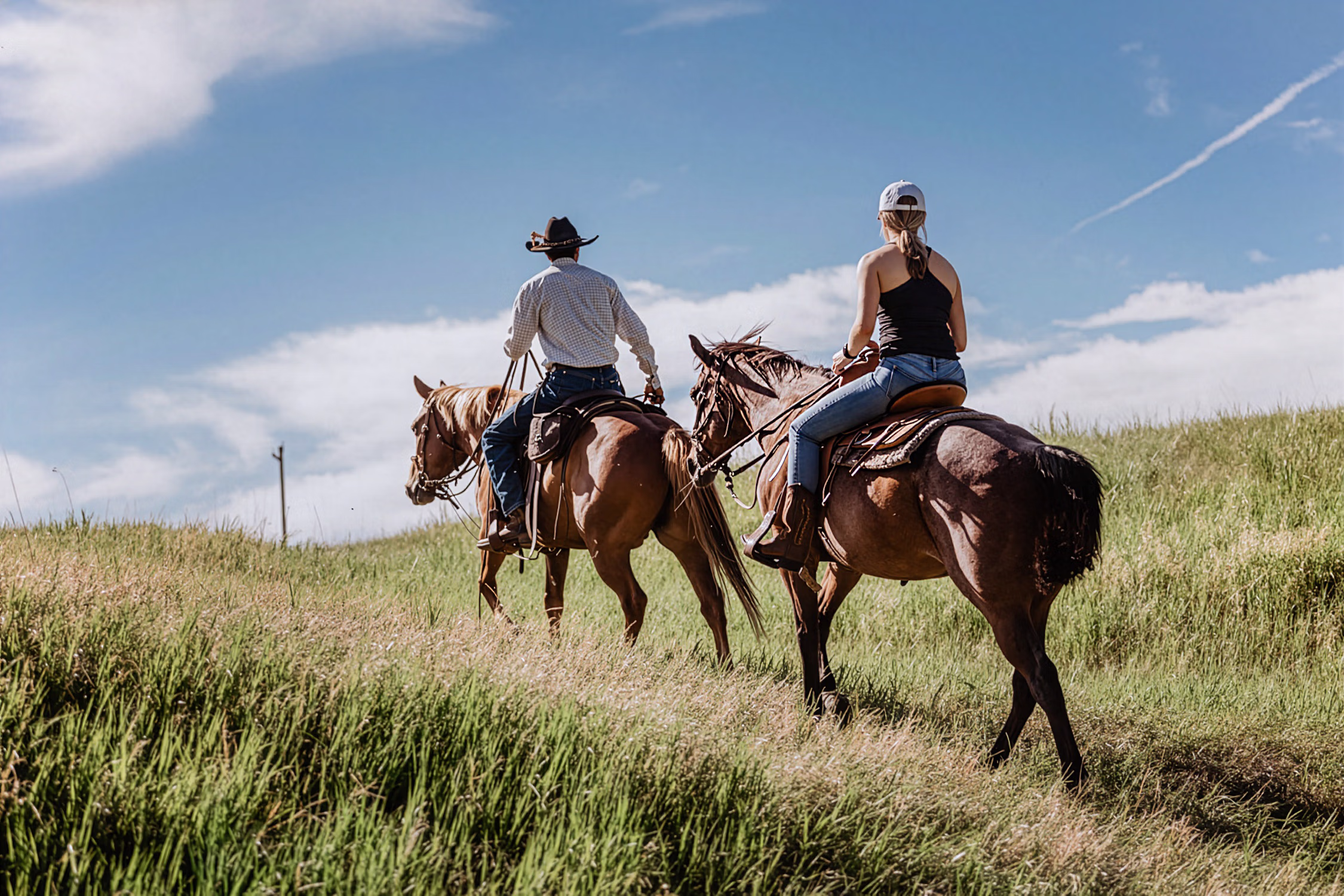 Un cavalier et un wrangler partant en randonnée à cheval au Circle Bar Ranch.