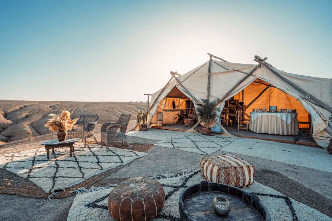 Un campement confortable installé au cœur du désert, avec une grande tente et un espace extérieur aménagé.