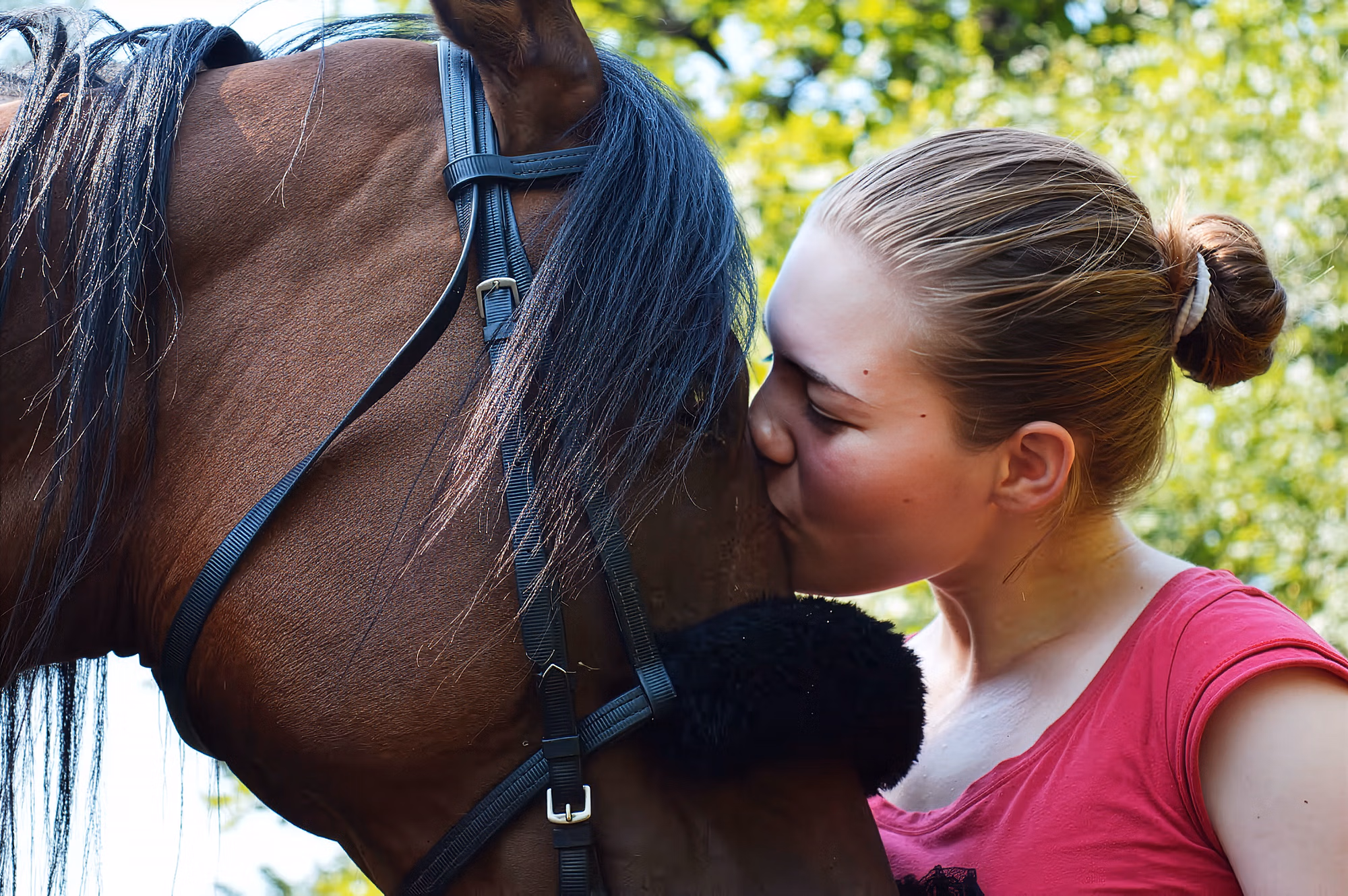 Une photo touchante d’une femme embrassant un cheval sur le front.