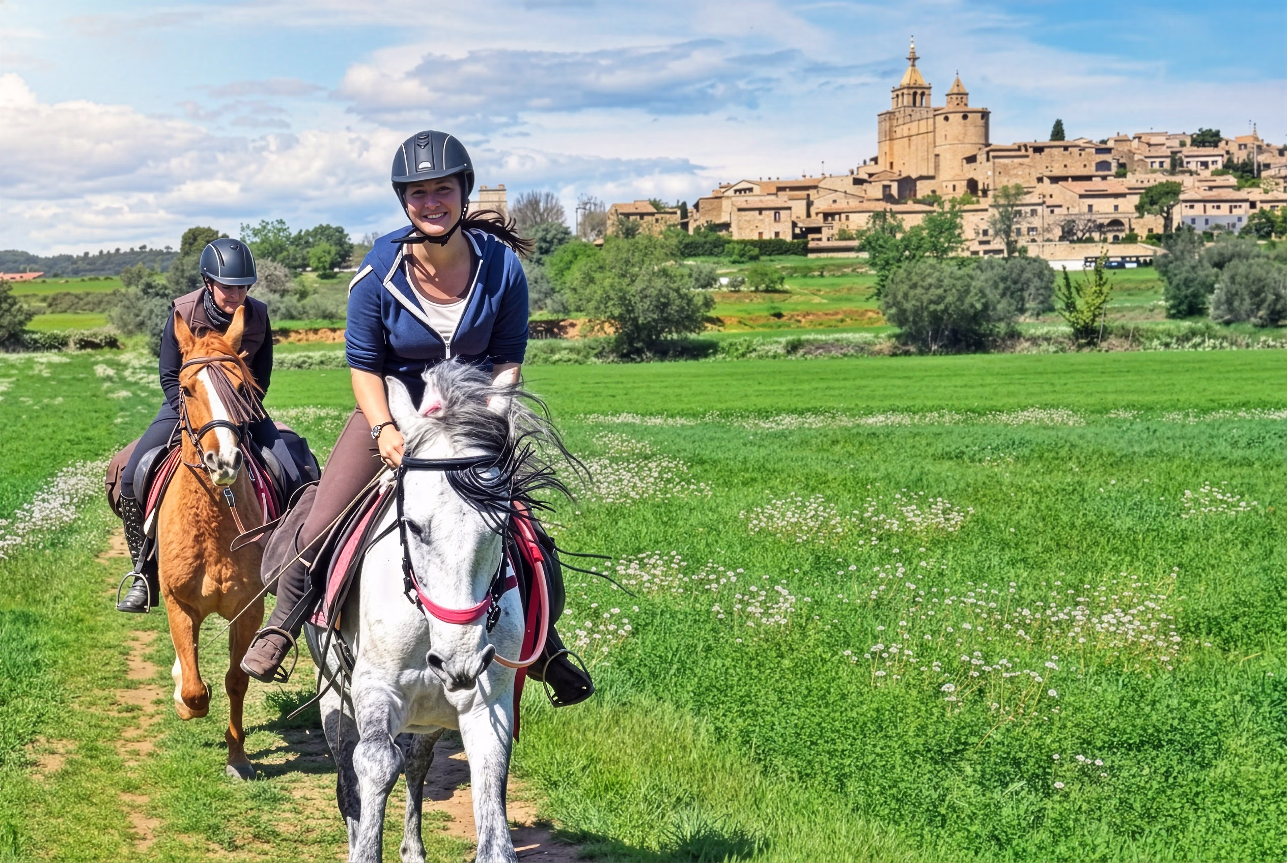 Deux cavaliers galopent lors d’une randonnée équestre en liberté en Espagne.