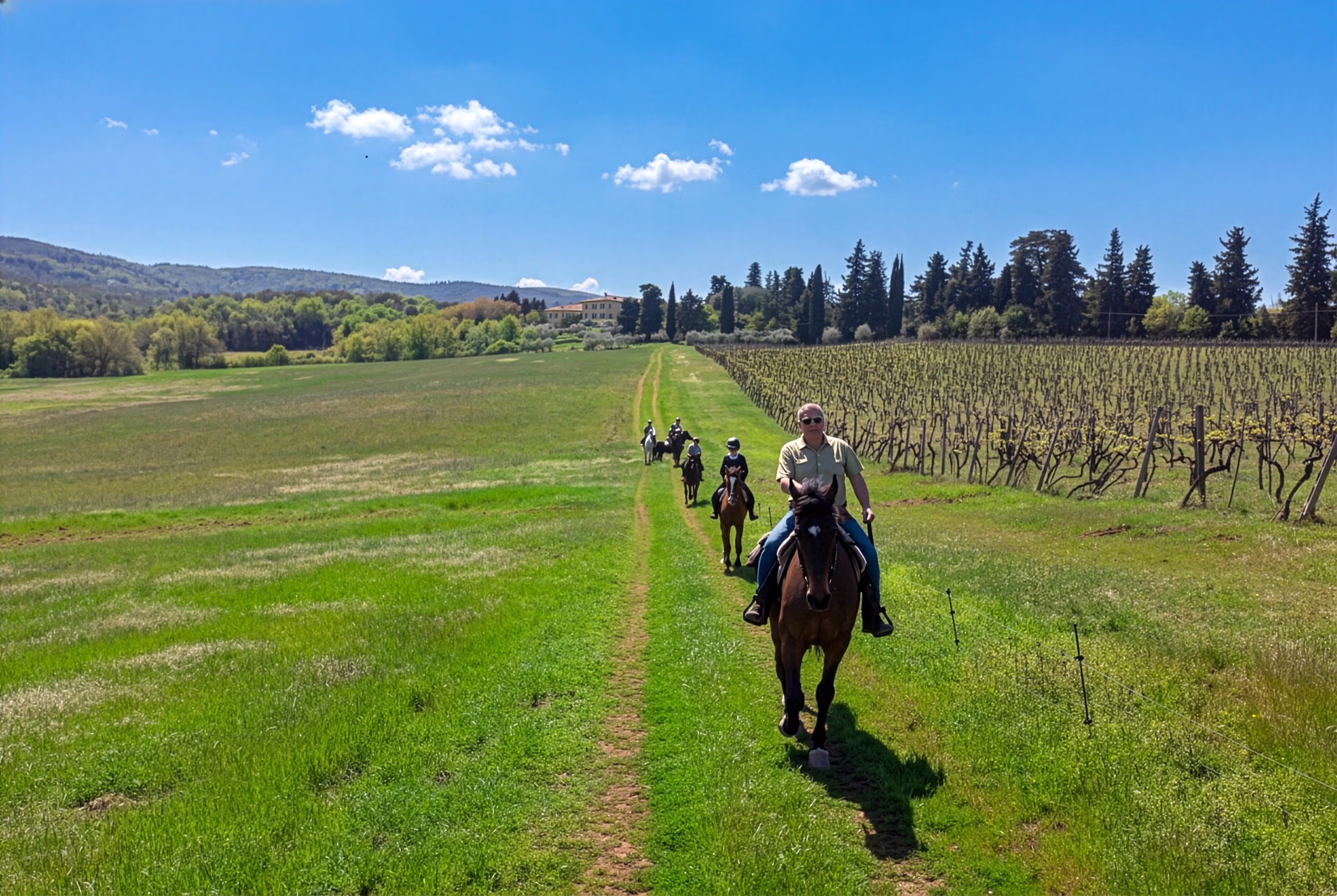 Des cavaliers galopent à travers la campagne toscane.