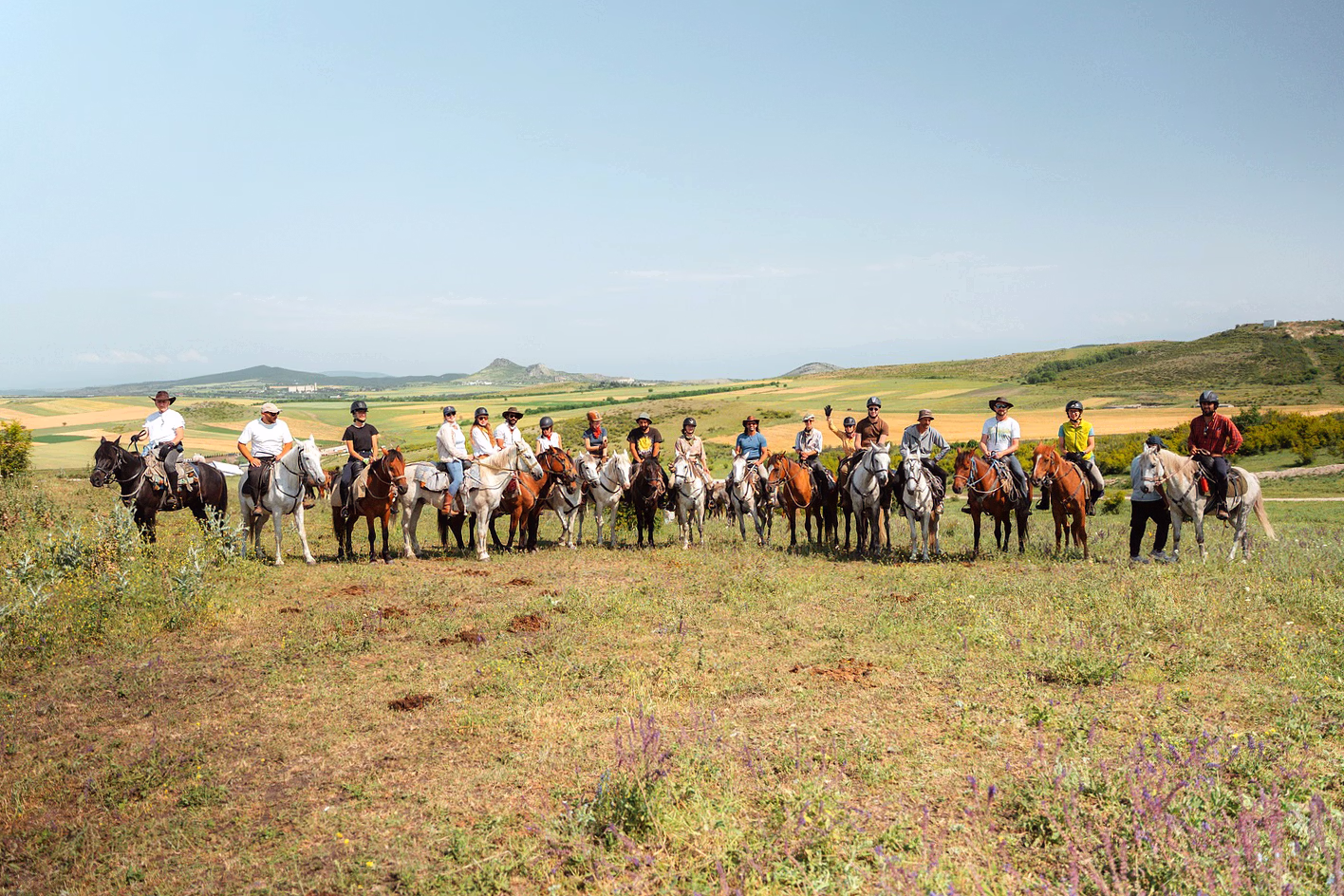 Un grand groupe de cavaliers alignés côte à côte à cheval pour une photo de groupe mémorable.